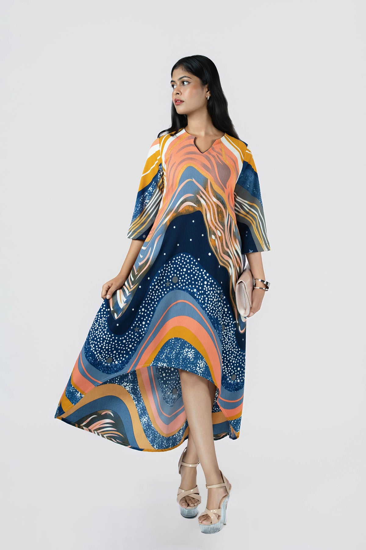 Stardust Flow Tunic: flowing tunic dress in a navy, orange and mustard wave print with a high-low hem, side view