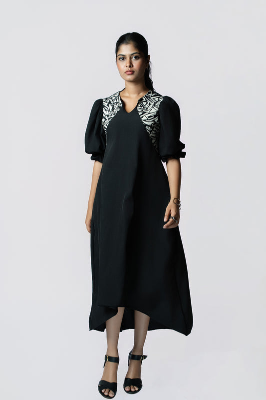 Monochrome Muse Midi: black puff-sleeve midi dress with black and white print trim at the neckline, front view