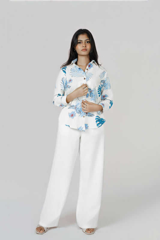 Isla Wide-Leg Linen Trousers: white 100% linen wide-leg trousers, worn with a blue leaf-print shirt, front view