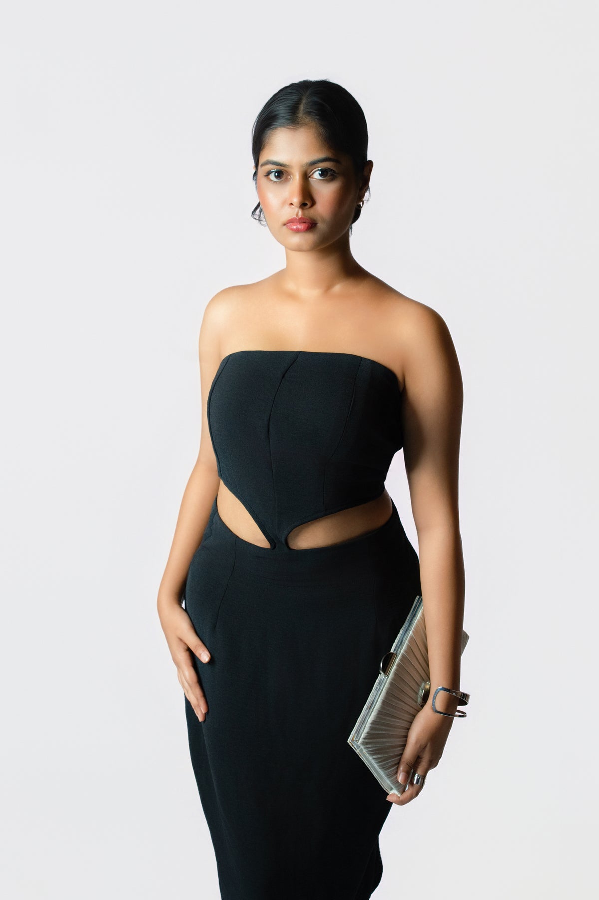 Velvet Eclipse Cutout Dress: black strapless fitted midi dress with waist cut-outs, close-up of the bodice