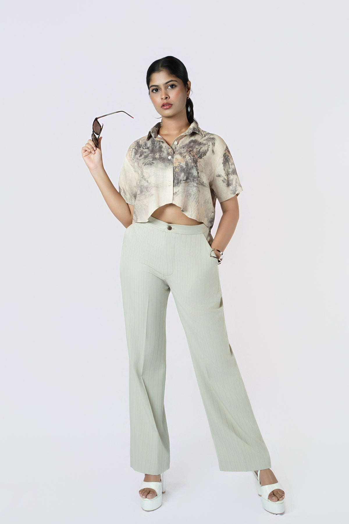 Willow Mist Crop Top: beige and grey brushstroke-print cropped cotton shirt with short sleeves, worn with sage trousers, front view
