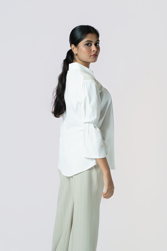 Ivory Textured Panel Blouse: ivory long-sleeve button-up blouse with textured lace panels, worn with sage trousers, side view