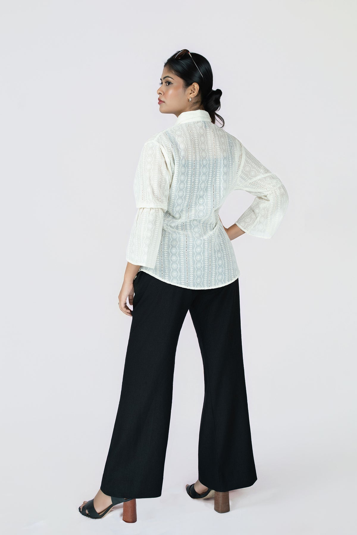 Midnight Grace Wide-Leg Trouser: black wide-leg trousers with a fluid drape, back view, styled with an ivory blouse