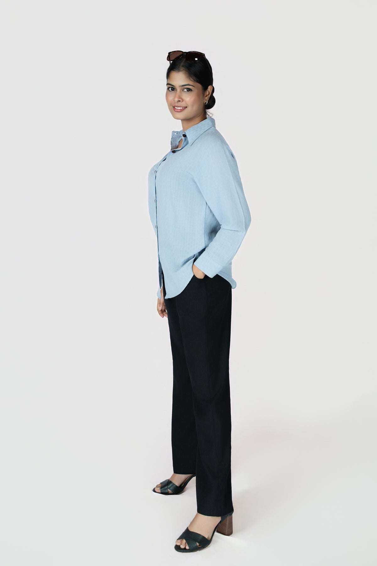 Midnight Grace Wide-Leg Trouser: black wide-leg trousers with a fluid drape, side view, styled with a blue shirt