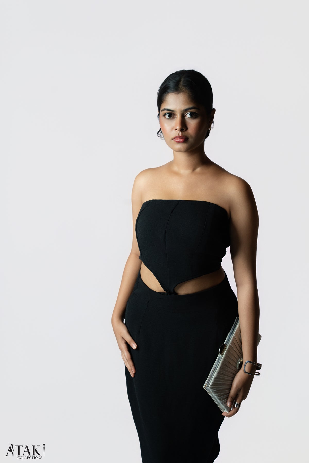Model in a black strapless dress with a sculpted bodice and waist cut-outs