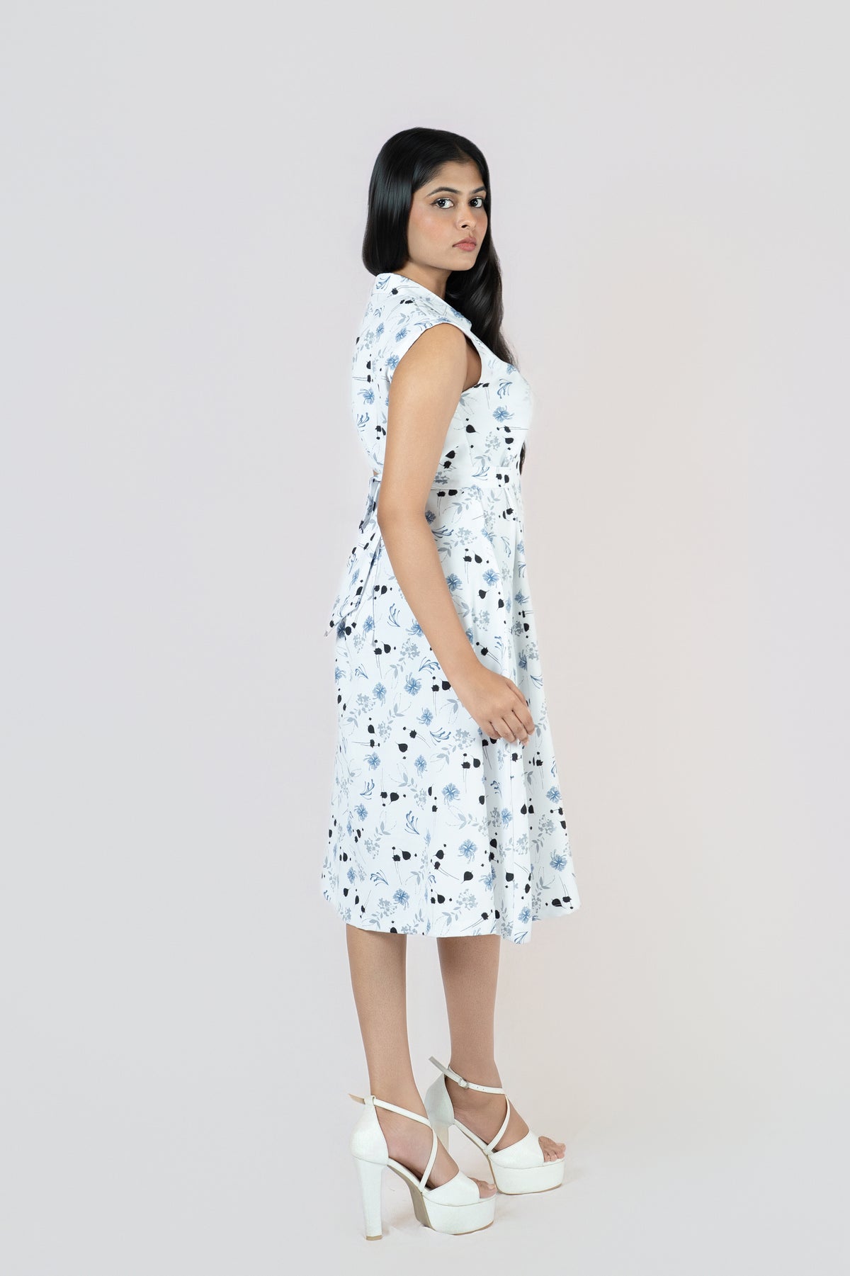 Petal Whirl Belted Dress: white sleeveless collared midi shirt dress with a scattered blue-black petal print and tie belt, side view