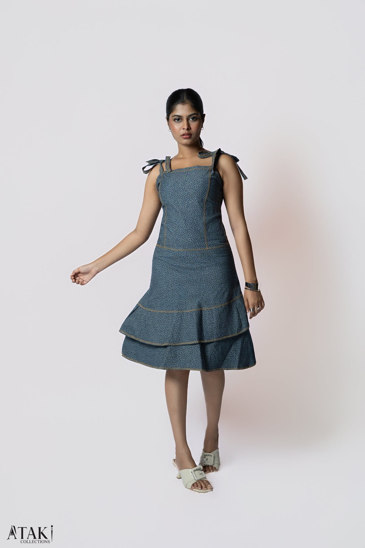 Model in a denim-blue sleeveless tiered dress with tie straps