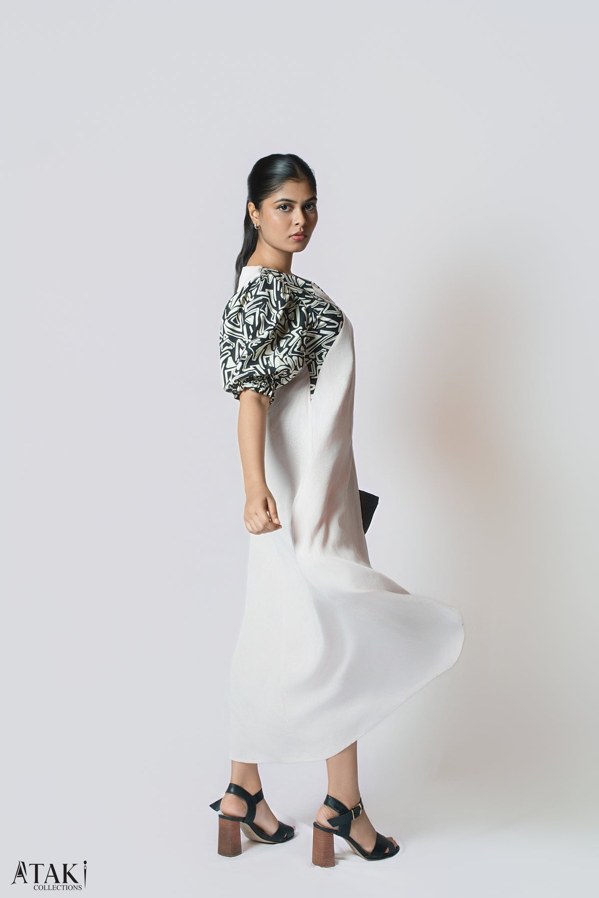 Model in a blush midi dress with black and white patterned puff sleeves