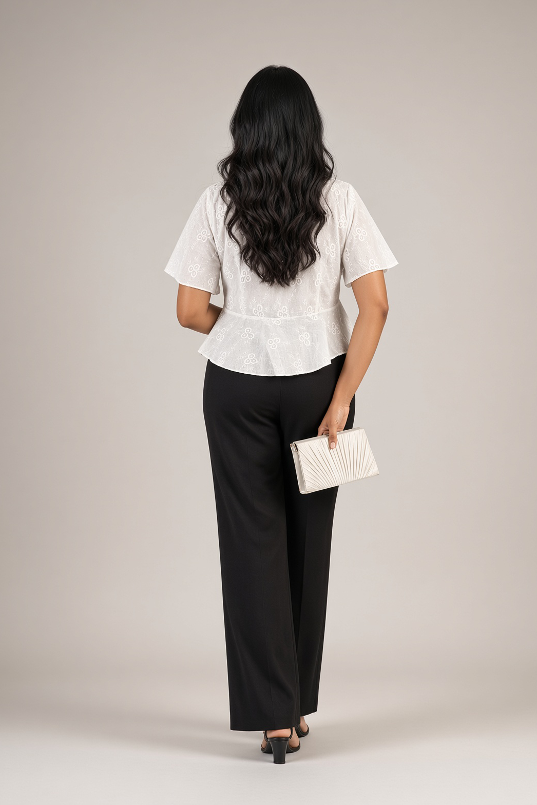 Petal Eyelet Top: white cotton eyelet peplum top with a V-neck and flutter sleeves, worn with black trousers, back view