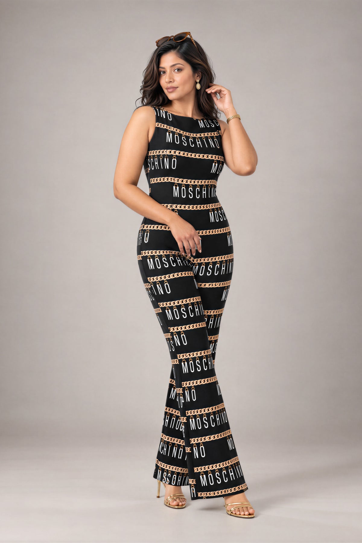 Chain Link Jumpsuit: black sleeveless flared-leg jumpsuit with a gold chain and lettering print, front view