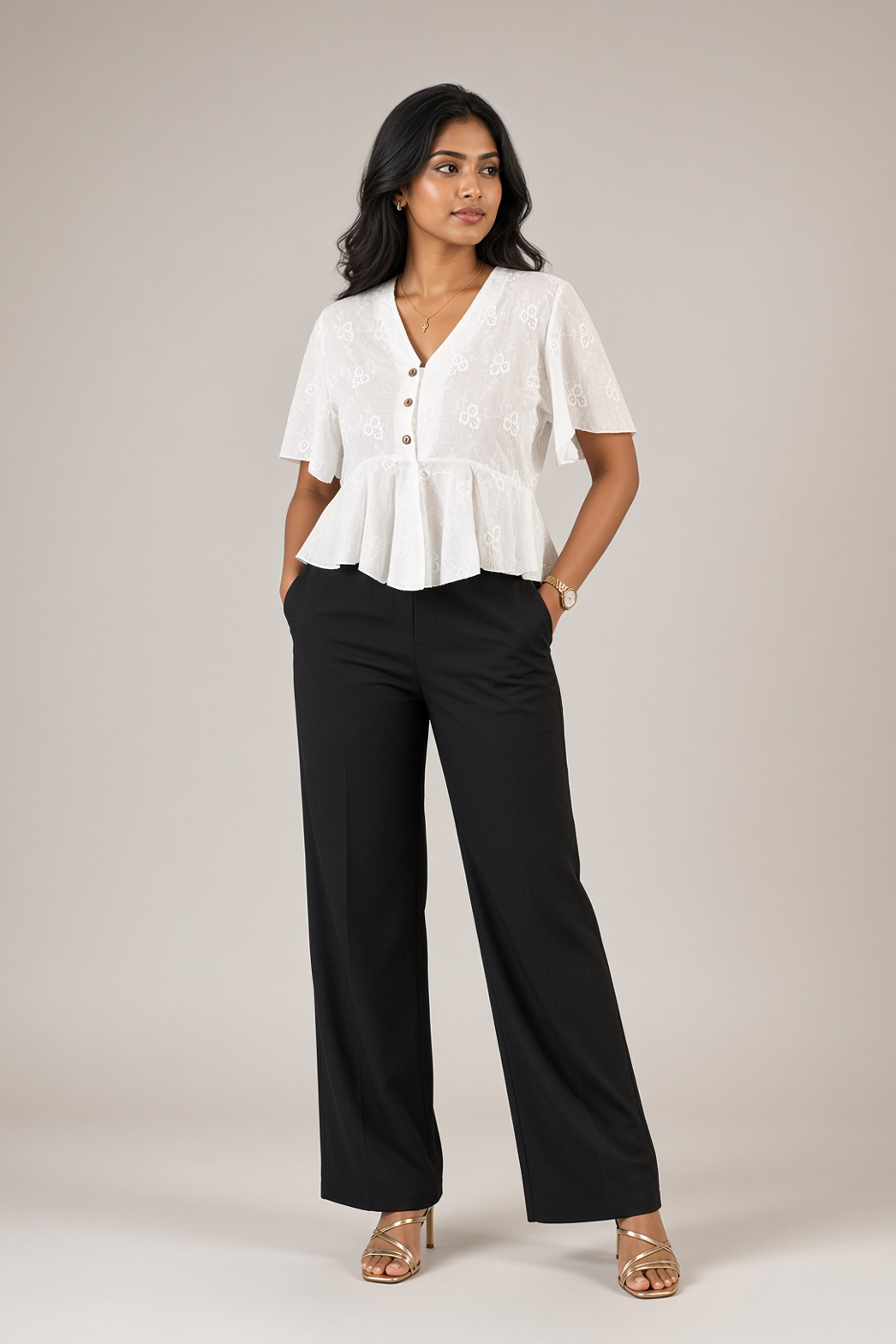Petal Eyelet Top: white cotton eyelet peplum top with a V-neck and flutter sleeves, worn with black trousers, front view
